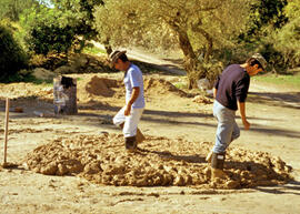
Reconstitution de l'habitat néolithique à Khirokitia (Chypre). La terre à bâtir, foulée au pied, est utilisée un ou plusieurs jours après sa préparation, selon l'utilisation projetée. Le malaxage est répété matin et soir et avant chaque emploi
