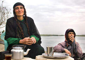 
Hommage à l'hospitalité syrienne. Portrait de femmes. Offrande du thé et pose cigarette des deux sœurs de Lawrence sur la terrasse de la maison, bords de l'Euphrate (Moyen Euphrate, Syrie)

