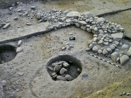 
Recherches franco-bulgares sur le site néolithique de Kovacevo en Bulgarie. Les structures. Mur de soubassement de la fin du Néolithique ancien dans le secteur M. Au premier plan, deux grandes fosses cylindriques
