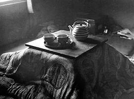 
Le Japon de 1937 à 1939 vu par André Leroi-Gourhan, dans un intérieur domestique, un système traditionnel de chauffage. Le Kotatsu couvert par un futon et une planhe. On remarque sur celle-ci une théière et deux tasses sur un plateau

